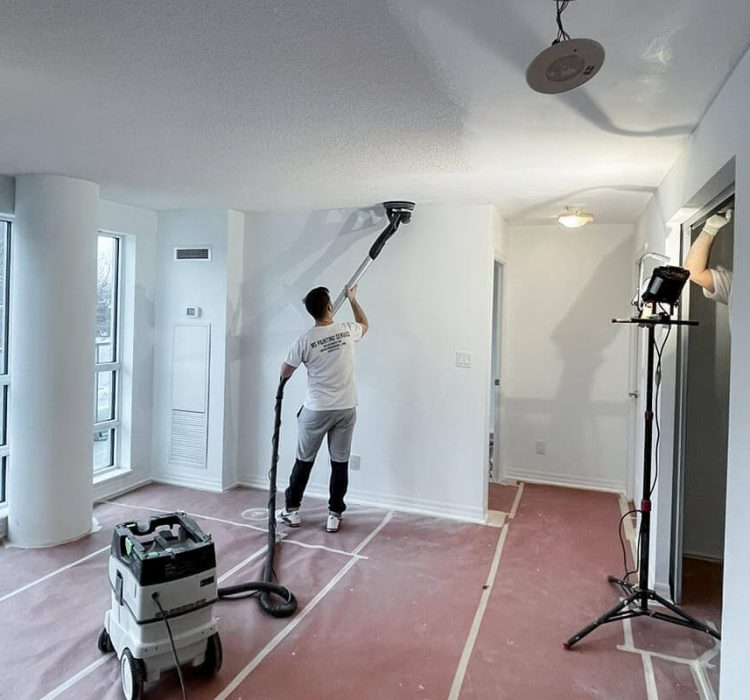 painter doing popcorn ceiling removal in a house using dustless sanding equipment